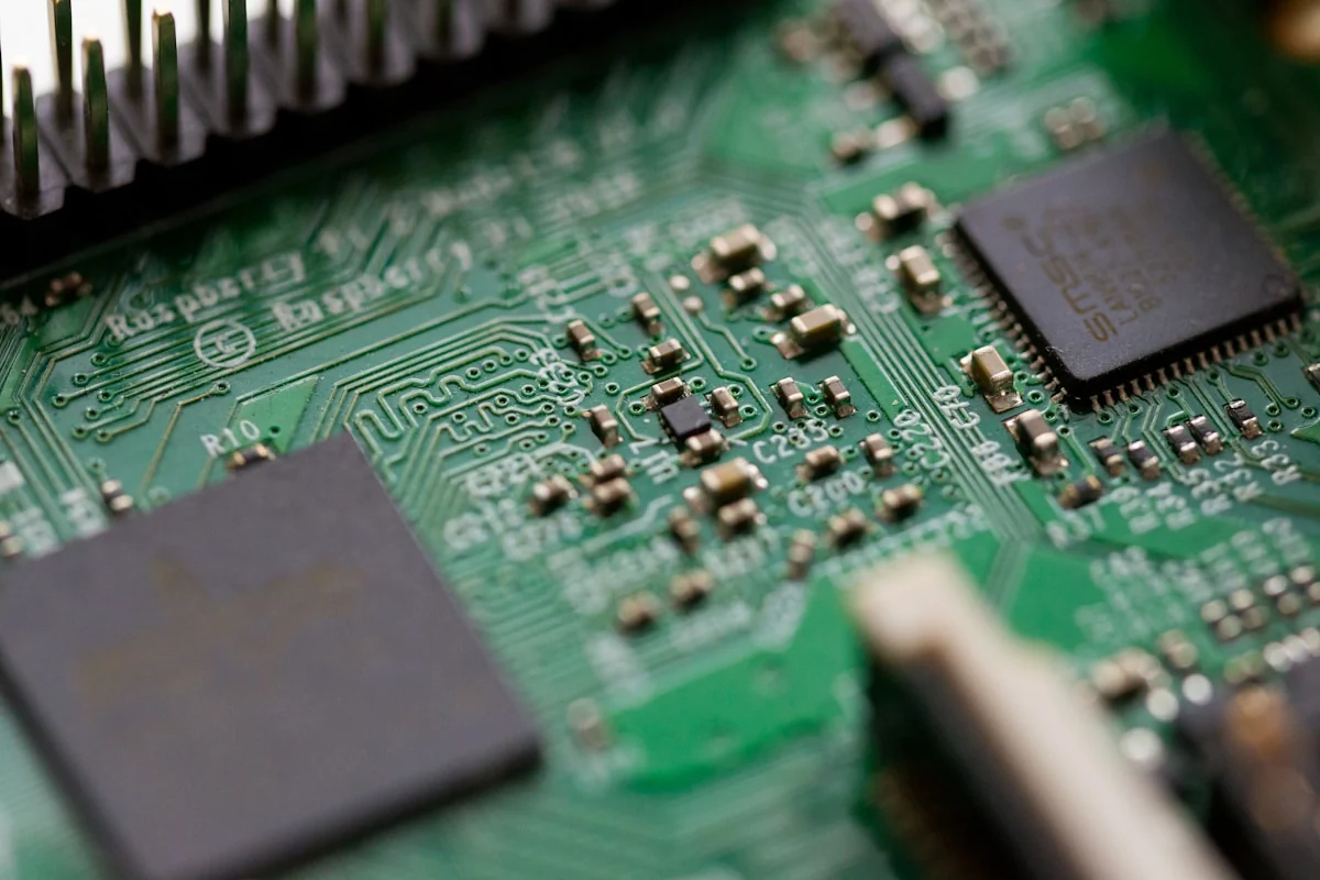Close-up macro view of various SMD components including chips, resistors, and capacitors mounted on a green PCB circuit board